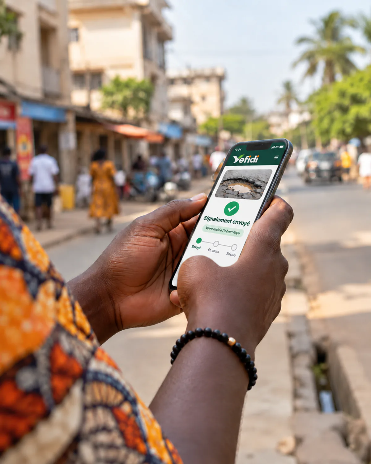 Mains tenant un téléphone dans une rue